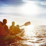 family kayaking on the ocean