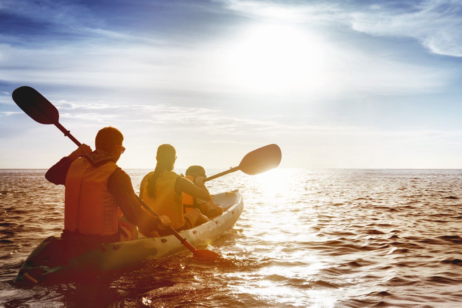 family kayaking on the ocean