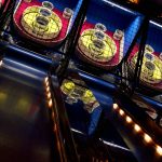 A series of skee-ball games lined up in an arcade. Try to roll 100,000.