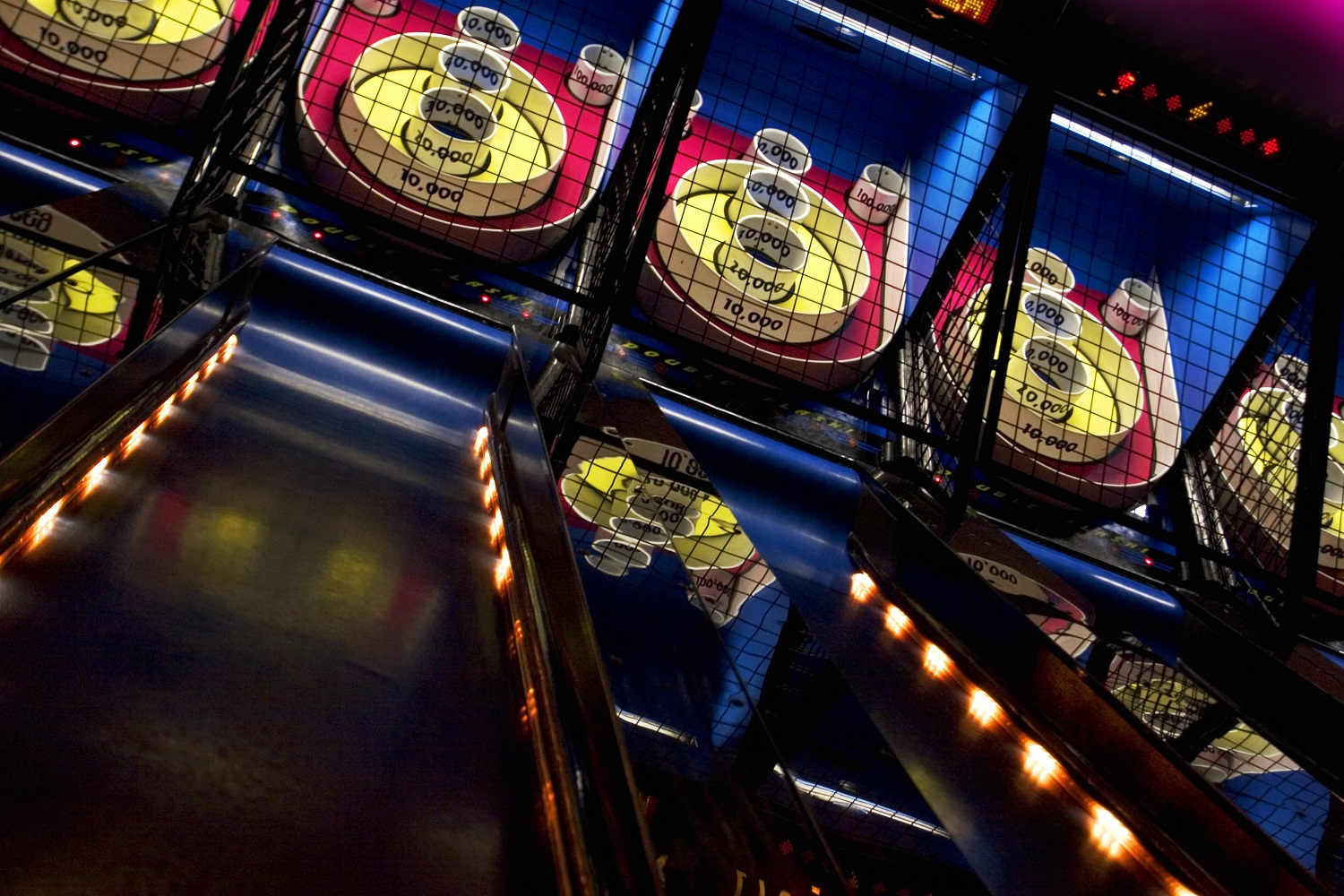 A series of skee-ball games lined up in an arcade. Try to roll 100,000.