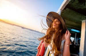 Happy woman enjoying the sea from ferry boat crossing Bosphorus in Istanbul